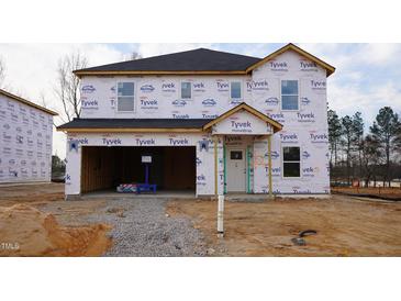 Unfinished two-story home with attached two-car garage, Tyvek HomeWrap, and dark roof shingles at 3857 Rosebush Dr, Zebulon, NC 27597