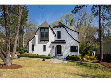 Charming white Tudor-style home with manicured landscaping and a welcoming front entrance at 5004 Lakemont Dr, Raleigh, NC 27609