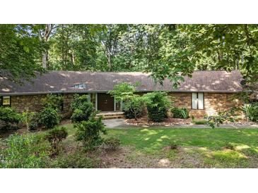 Charming stone home featuring a unique roofline and lush landscaping at 8805 Leesville Rd, Raleigh, NC 27613