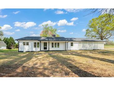 Charming white ranch home with black trim and a well-manicured lawn offers simple elegance at 8917 Fowler Rd, Zebulon, NC 27597