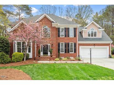 Beautiful two-story brick home with a well-manicured lawn and charming landscaping at 105 Fifemoor Ct, Cary, NC 27518