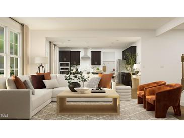 Bright, open-concept living space with modern furnishings, an L-shaped couch, and views of the kitchen at 1717 Goldfinch Perch Ln, Knightdale, NC 27545