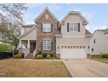 Charming two-story home featuring a stone facade, covered porch, and a well-manicured front yard at 2001 Lilly Brook St, Fuquay Varina, NC 27526