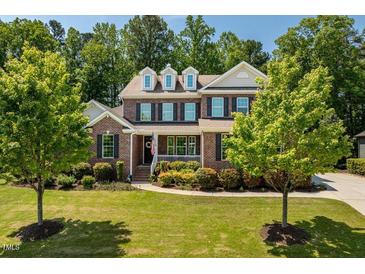 Beautiful two-story brick home featuring a lush green lawn and mature trees at 2421 Trenton Park Ln, Raleigh, NC 27607