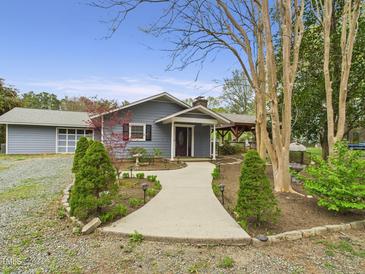 Charming single-story home featuring a landscaped front yard and inviting walkway to the front door at 2920 Ode Turner Rd, Hillsborough, NC 27278