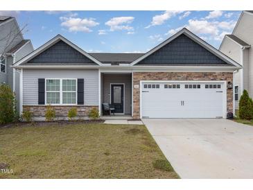 Charming single-story home featuring stone accents and a two-car garage at 303 Azalea Gaze Dr, Youngsville, NC 27596