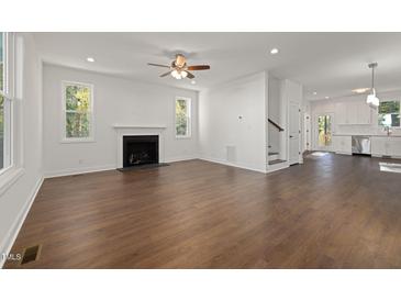 Bright living room features wood floors, fireplace, neutral walls, and plenty of natural light at 306 Cecil St, Durham, NC 27707