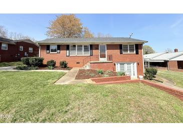 Charming red brick home with well-maintained lawn and tidy landscaping at 310 Meadowbrook Dr, Burlington, NC 27215