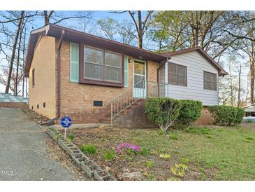 Charming brick and siding home with lovely front yard landscaping and light blue shutters and trim at 3416 North Ridge Dr, Sanford, NC 27330