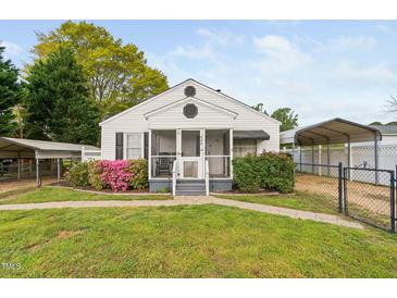Charming home featuring a cozy, screened front porch and well-maintained landscaping at 440 S Church St, Coats, NC 27521