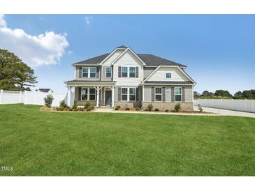Charming two-story home with gray siding, black shutters, covered porch and a well manicured front lawn at 45 Pond Mountain Dr, Clayton, NC 27520