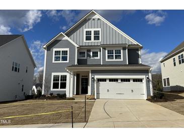 Charming two-story home features a two-car garage, and a well-manicured front yard at 5021 Aged Pine Dr # 55, Apex, NC 27523