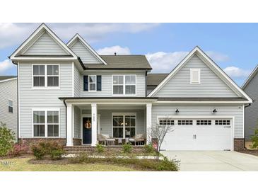 Charming two-story home with a well-manicured lawn, a covered porch and a two car garage at 705 Marshall Farm St, Wake Forest, NC 27587