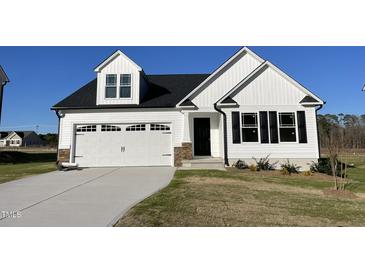 Charming white home featuring a two-car garage, black shutters, and a well-manicured lawn at 77 Heatherglenn Cir, Princeton, NC 27569
