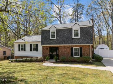 Charming two-story home with brick and siding, dormer windows, landscaped front yard, and a walkway to the front door at 1108 Medlin Dr, Cary, NC 27511