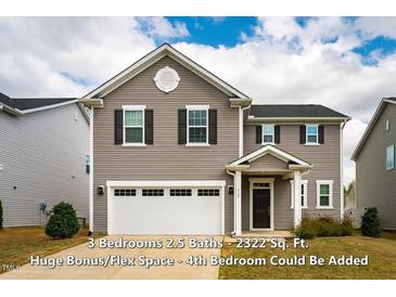 Two-story home with gray siding, black shutters, and a two-car garage, providing classic curb appeal at 112 Willow Grove Ln, Fuquay Varina, NC 27526