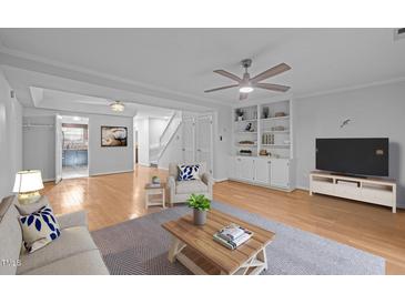 Comfortable living room features neutral colors, built-in shelving and a ceiling fan at 1220 Manassas Ct Ct # E, Raleigh, NC 27609