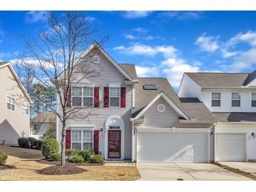 Charming two-story home with red shutters, attached garage and landscaped front yard, under blue skies at 125 Hidden Springs Dr, Durham, NC 27703