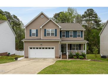 Charming two-story home with a well-manicured lawn, a two-car garage, and a welcoming front porch at 136 Ashlyn Ridge Dr, Garner, NC 27529