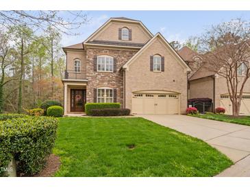 Charming home with a well-manicured lawn, brick and stone facade, and a two-car garage at 144 Arabella Ct, Cary, NC 27518