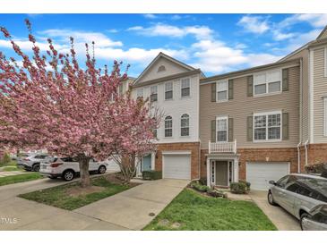 Charming townhomes featuring brick accents, attached garages, and a beautiful flowering tree at 208 Chandler Chase Ct, Morrisville, NC 27560