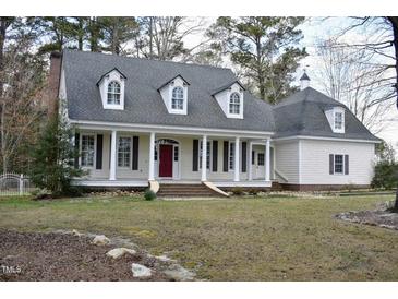 Charming home featuring a classic front porch with stately columns and a vibrant red front door at 218 Keith Hills Rd, Lillington, NC 27546