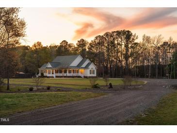 Charming single-story home with a welcoming front porch, nestled on a spacious lot with lush trees at 2905 Glendale Rd, Kenly, NC 27542