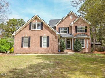 Inviting two-story brick home featuring classic shutters and a well-manicured lawn at 2932 Candlehurst Ln, Raleigh, NC 27616