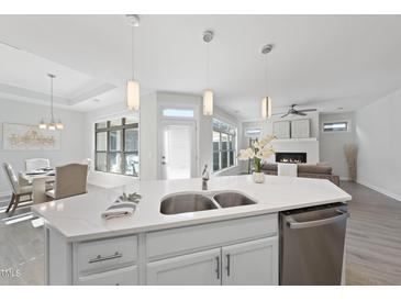Bright, open kitchen featuring stainless steel appliances, quartz countertops, and views to living room and dining area at 301 Crayton Oak Dr, Cary, NC 27519