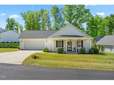 Charming single-story home with a manicured lawn, a covered front porch, and an attached two car garage at 374 Ashley Woods Ct, Clayton, NC 27527