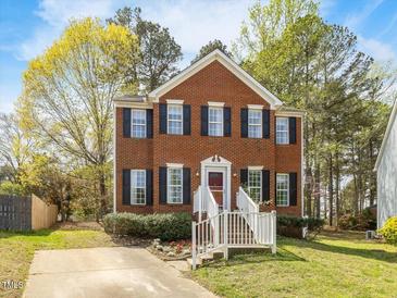 Charming two-story brick home with well-maintained lawn and inviting white railed front porch and mature trees at 5 Maidenhair Ct, Durham, NC 27703