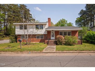 Charming two-story home featuring a brick facade, covered front porch, and well-maintained lawn at 506 N Harrison Ave, Cary, NC 27513