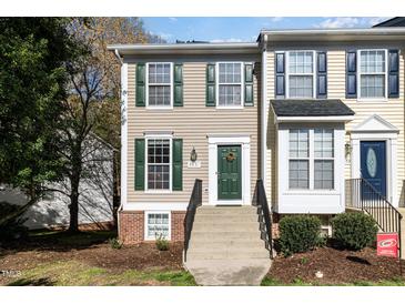 Charming two-story townhome featuring beige siding, green shutters, and a welcoming front entrance with a green door at 5551 Vista View Ct, Raleigh, NC 27612