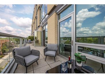 Relaxing balcony seating with city views, featuring modern furniture and an outdoor dining area at 601 W Rosemary St # 418, Chapel Hill, NC 27516
