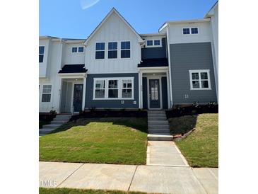 Charming townhome with well-manicured lawn and inviting front entrance on a sunny day at 609 Callan View Ave, Wake Forest, NC 27587