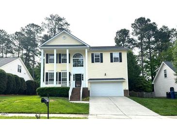 Charming two-story home with white columns, green lawn, and attached two-car garage at 6705 Somerknoll Dr, Durham, NC 27713
