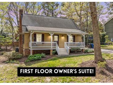 Charming home featuring a cozy porch, landscaped yard, and a classic brick chimney at 7317 Mill Ridge Rd, Raleigh, NC 27613