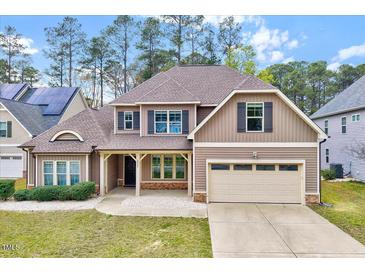 Charming two-story home with brick accents, attached two-car garage and manicured front lawn at 8932 Buffalo Gourd Ln, Angier, NC 27501