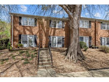 Charming brick townhome featuring a welcoming entrance with stairs and mature tree at 103 Friar Ln, Carrboro, NC 27510