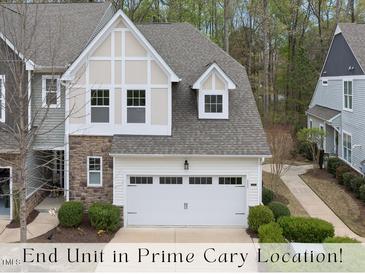 Charming end-unit townhome featuring stone accents, attached two-car garage, and manicured landscaping at 111 Wards Ridge Dr, Cary, NC 27513