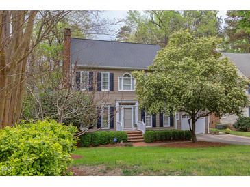 Charming two-story home features a brick chimney, a well-maintained lawn, and mature trees at 1159 Belfair Way, Chapel Hill, NC 27517
