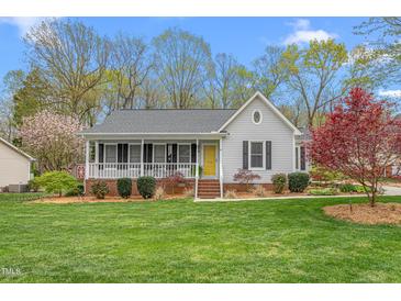 Charming single story home with a well-maintained lawn, inviting porch, and attractive landscaping at 124 Holly Ridge Ln, Mebane, NC 27302