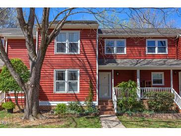 Charming townhouse with red siding, manicured landscaping, and inviting front porch at 125 Long Shadow Pl, Durham, NC 27713