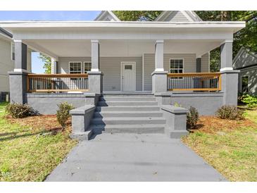 Charming front porch with gray stairs, railings, and white columns offers a welcoming entrance at 129 Burwell Avenue Ave, Henderson, NC 27536