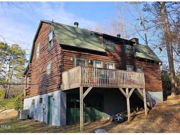 Rustic log cabin with a large deck overlooking the yard, offering a unique and charming living space at 207 High House Rd, Cary, NC 27513