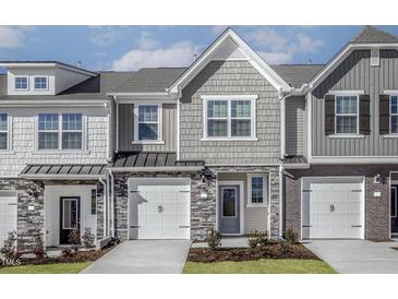 Charming townhome featuring a stone and shingle facade, attached garages, and neatly landscaped front yards at 2118 Willow Gln Dr, Graham, NC 27253