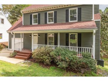 Charming two-story home featuring a covered front porch and nicely landscaped front yard at 302 Rushingwater Dr, Cary, NC 27513