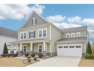 Charming two-story home with an attached garage, covered porch, and beautifully landscaped front yard at 3348 Table Mountain Pine Dr, Raleigh, NC 27616