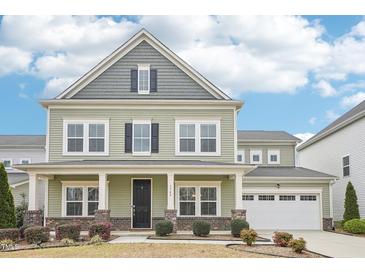 Charming two-story home with a covered front porch, a two-car garage, and landscaped front yard at 3348 Table Mountain Pine Dr, Raleigh, NC 27616