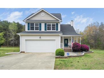Charming two-story home featuring a well-manicured lawn, attached garage, and inviting front porch at 3690 Mabel Ln, Stem, NC 27581